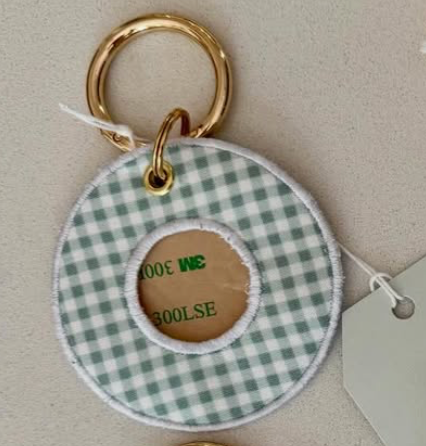 Round fabric keychain with green and white gingham pattern and gold ring