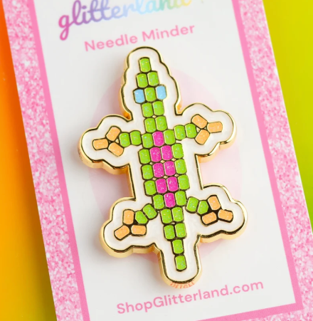 Green caterpillar needle minder with pink and blue details