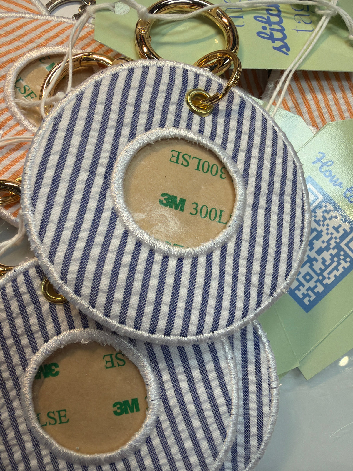 Round blue and white striped fabric tags with gold rings