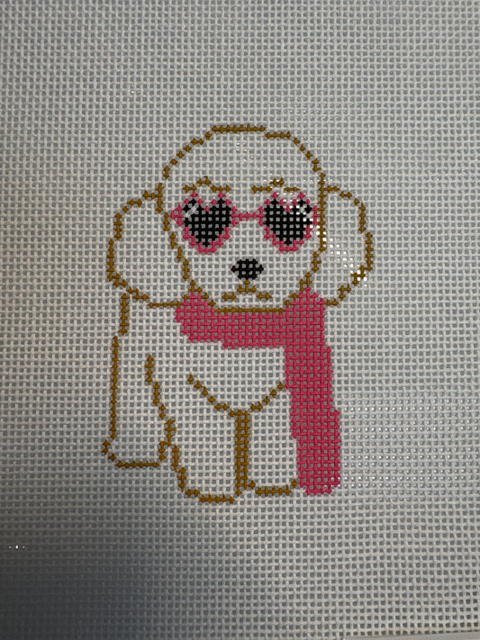 Cross-stitched design of a puppy with sunglasses and a pink muffler.