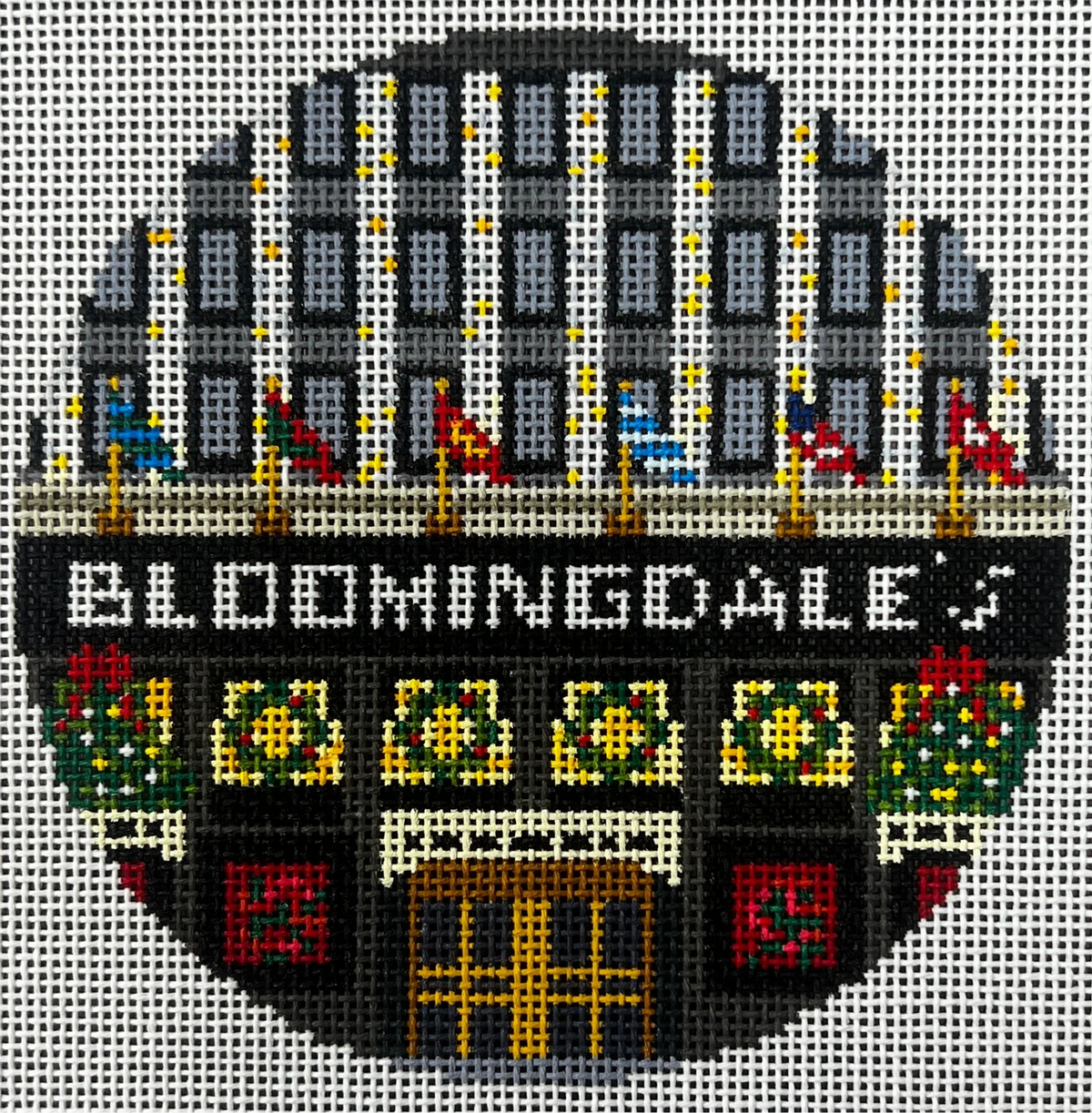 Cross-stitched design of a building with 'Bloomingdale' text and decorative elements.