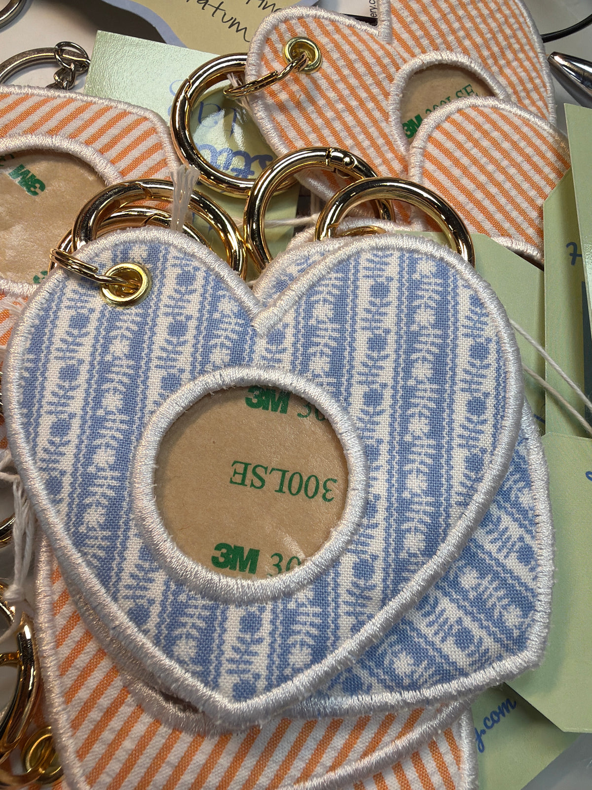 Heart-shaped fabric keychain with blue and white pattern and gold ring