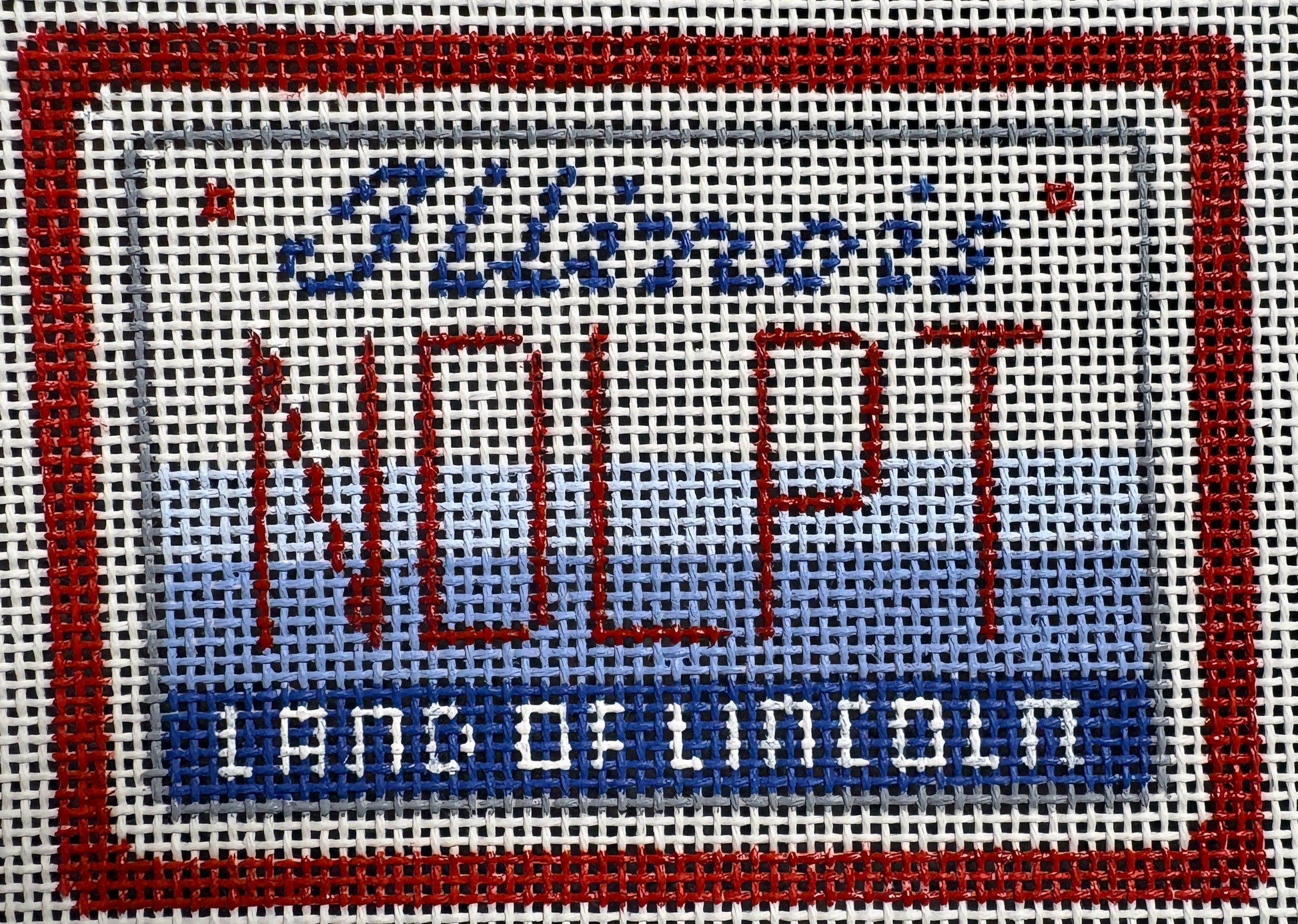 Cross-stitched design of a sign with text and border