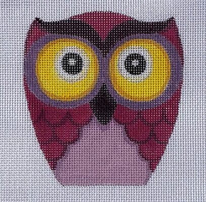 A needlepoint canvas featuring a stylized owl design with large yellow eyes