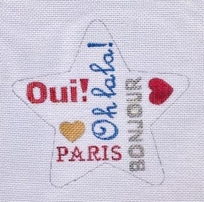 Paris-themed star-shaped needlepoint design with colorful text and hearts