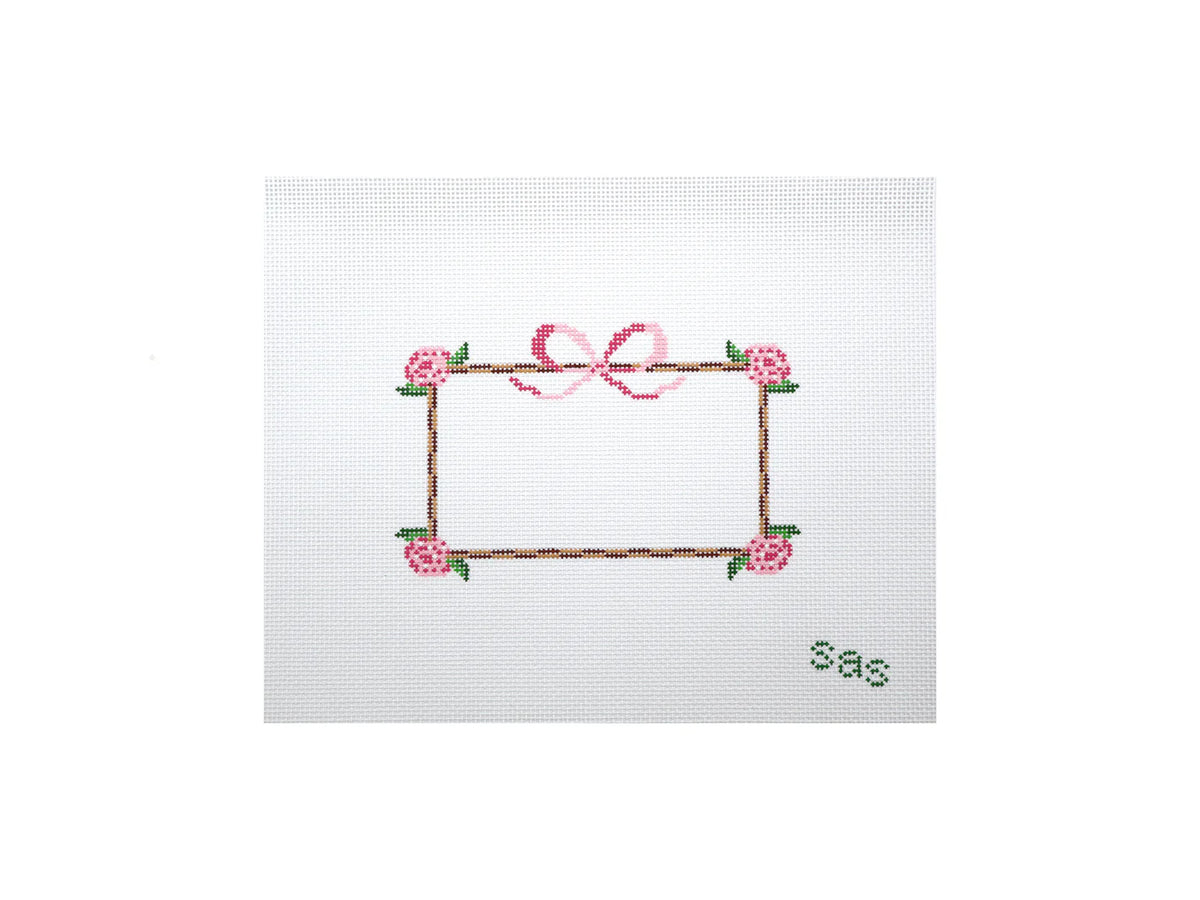 Embroidered design of a frame with flowers and a bow on a white background
