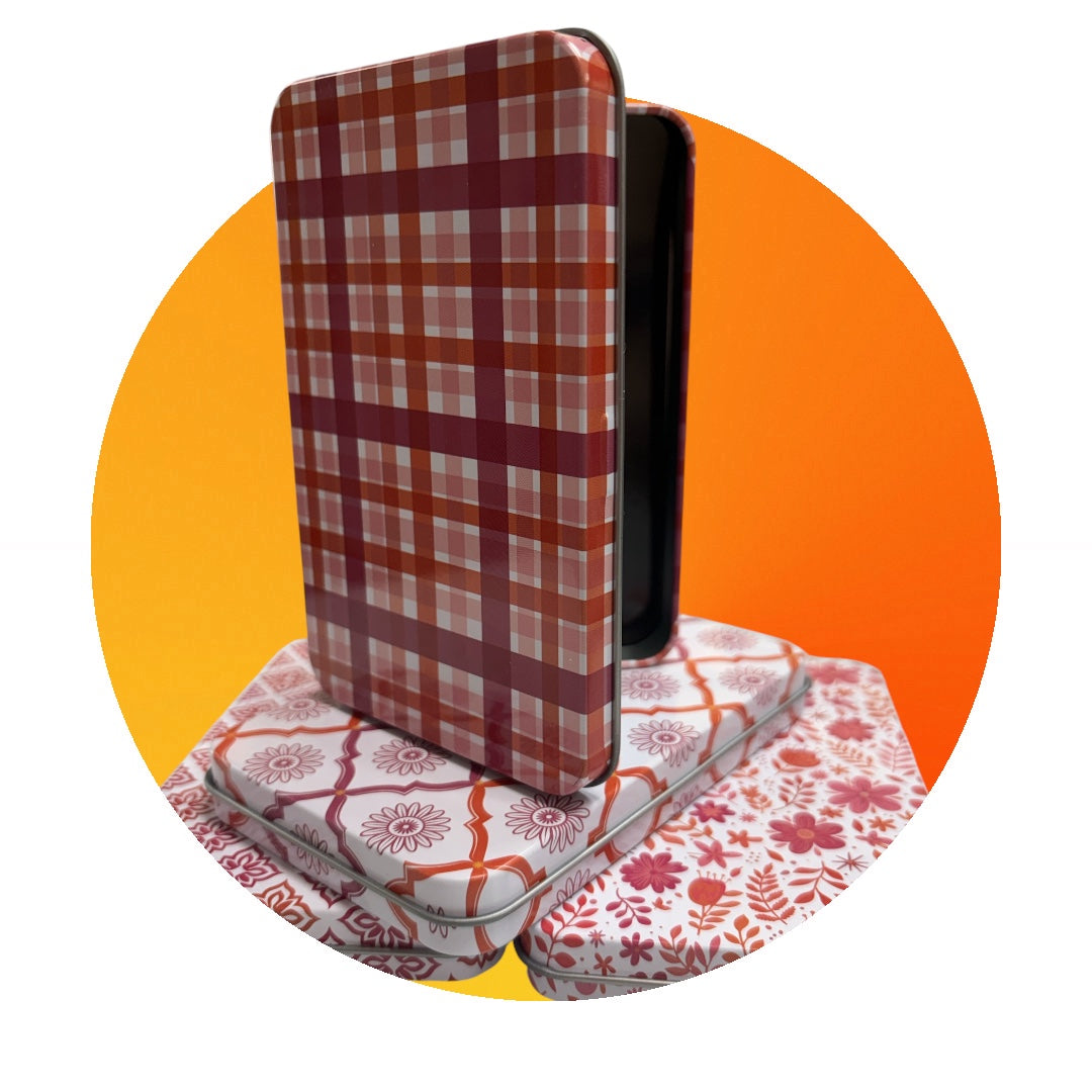 Plaid-patterned phone case on a floral-patterned stand with an orange circle background