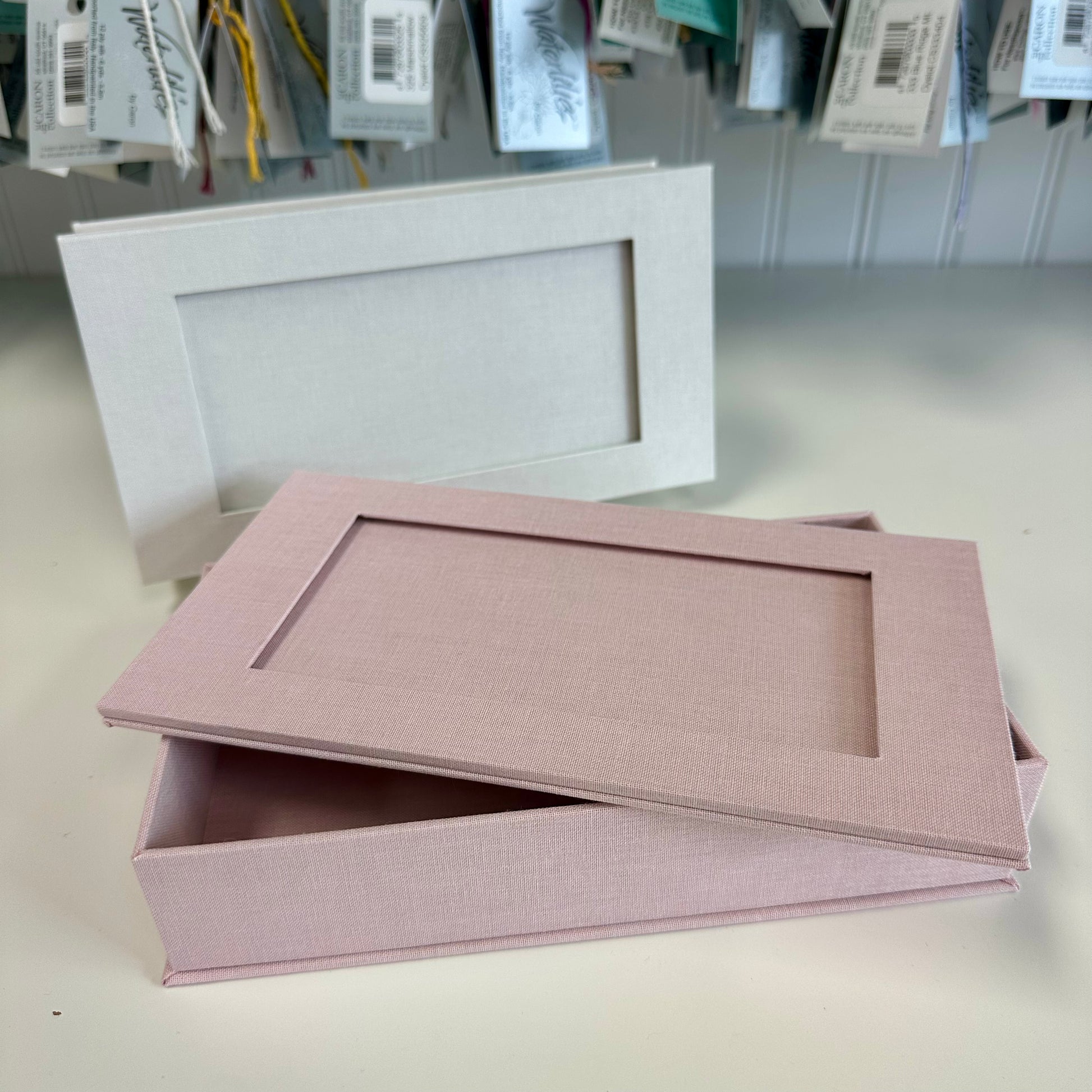 Pink rectangular box with a matching lid on a light gray surface.