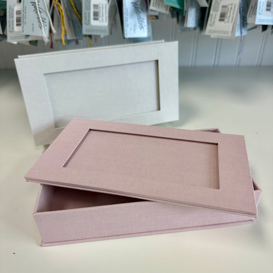 Pink rectangular box with a matching lid on a light gray surface.