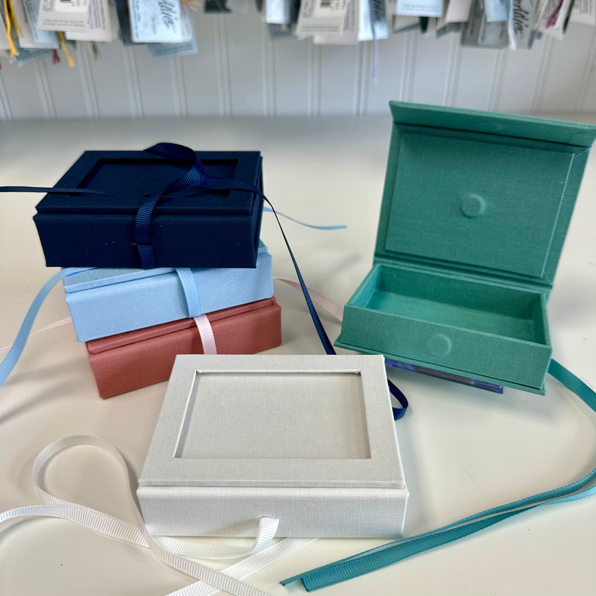 Collection of jewelry boxes in various colors on a white surface.
