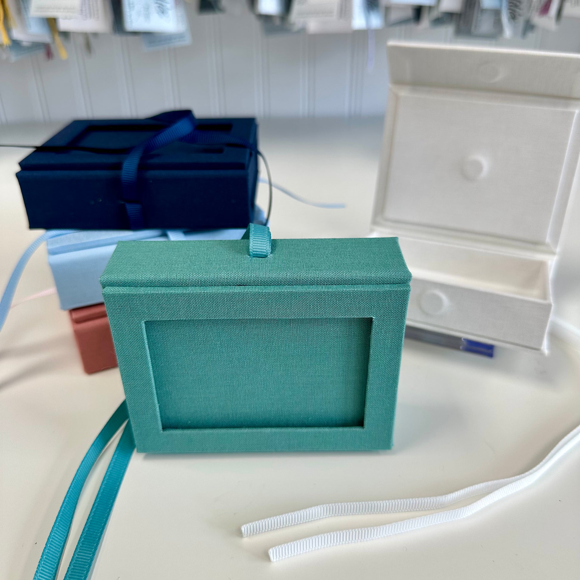 Teal jewelry box with a strap on a white surface