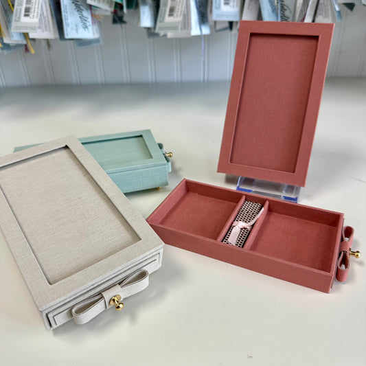 Jewelry boxes in various colors on a white surface