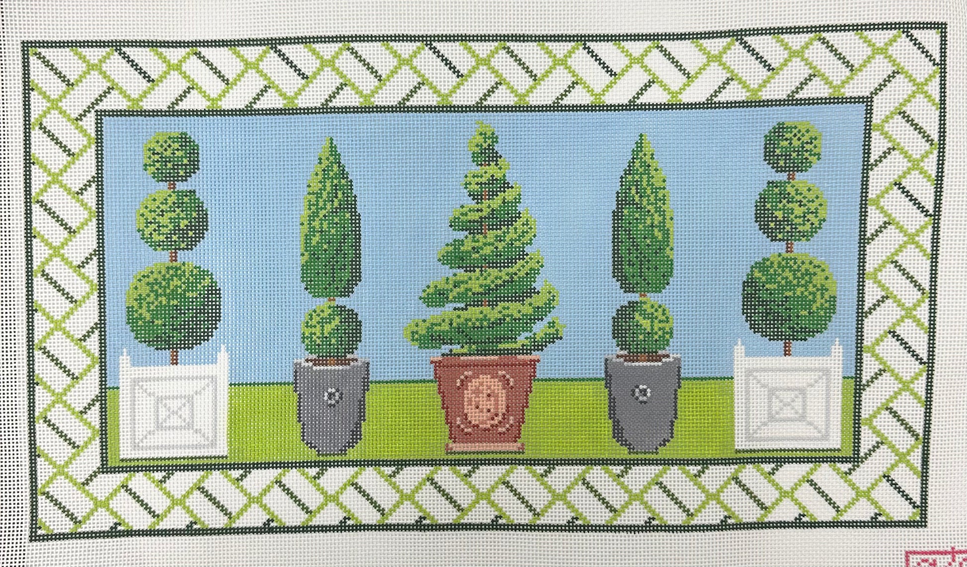 Decorative needlepoint of potted trees with a geometric border