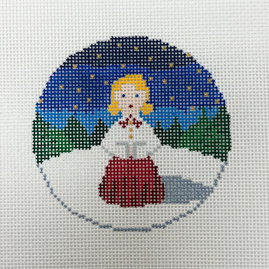 Cross-stitched design of a fairy in a snowy landscape with a blue sky.
