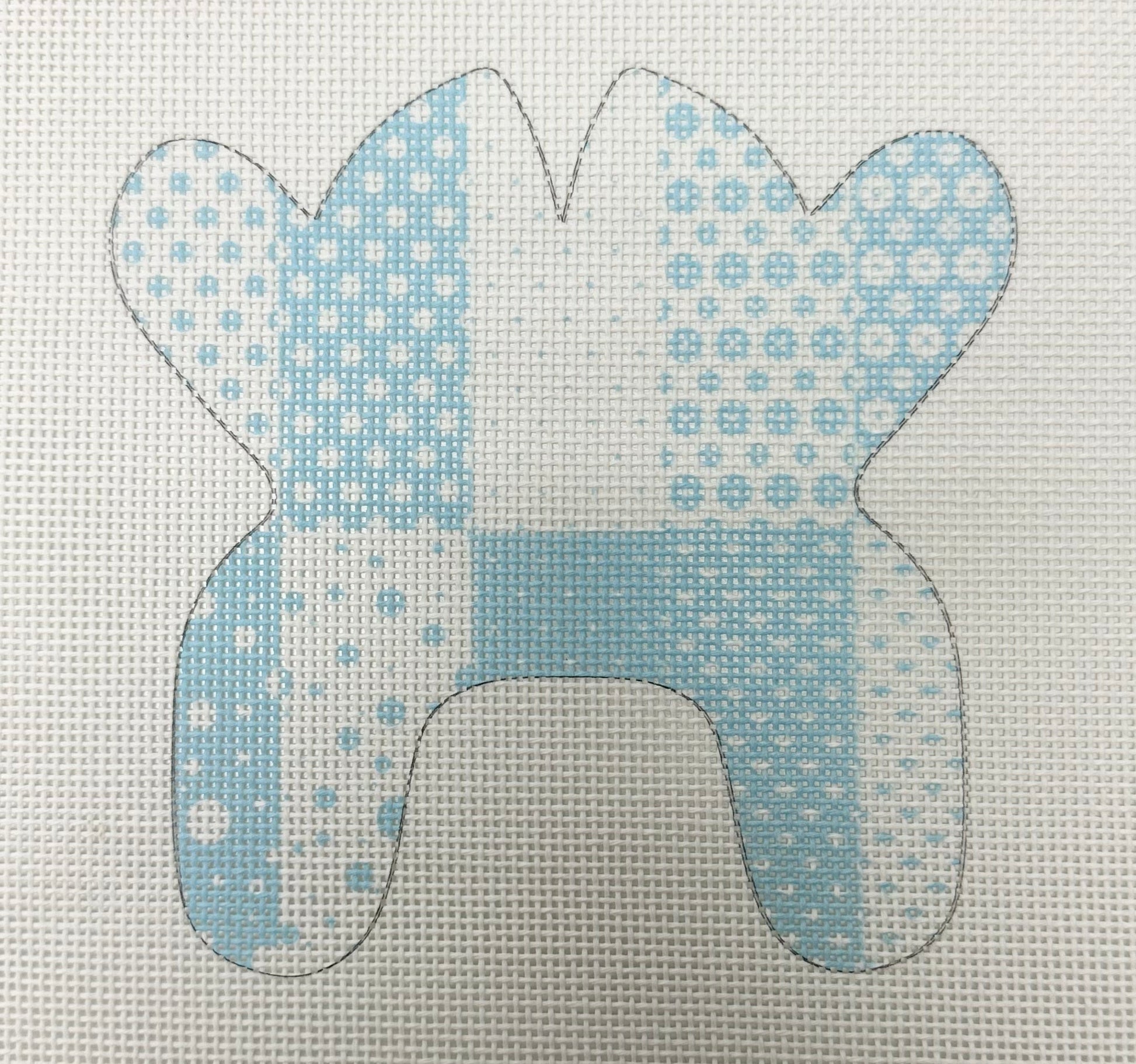 Blue and white patterned fabric cutout of a dog's head on a light gray background