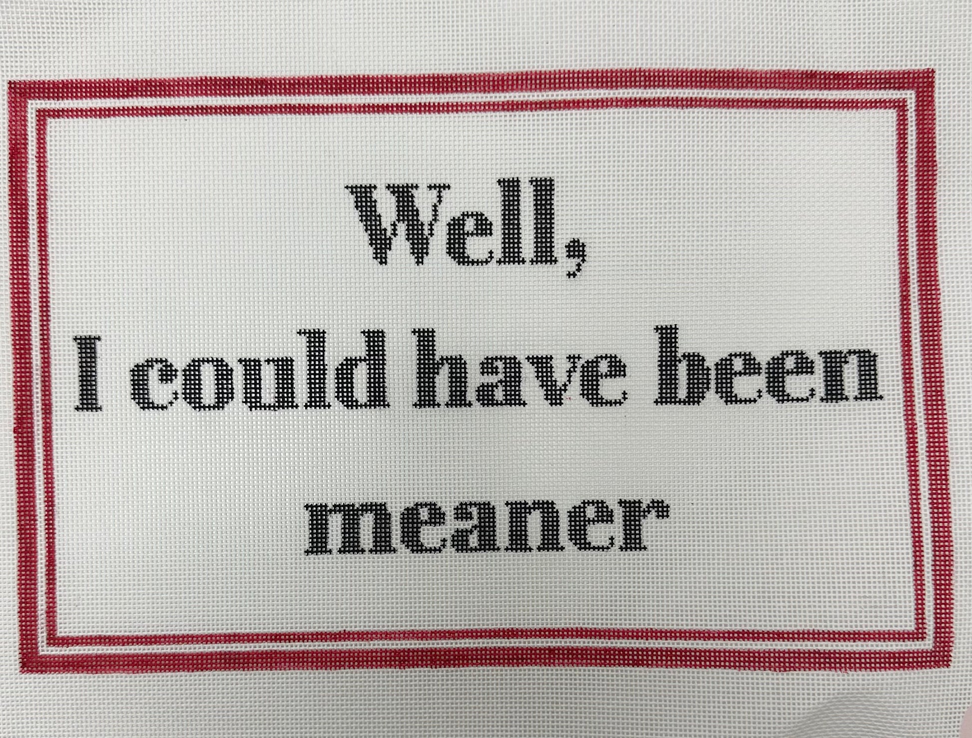Text on fabric that reads 'Well, I could have been meaner' with a red border.