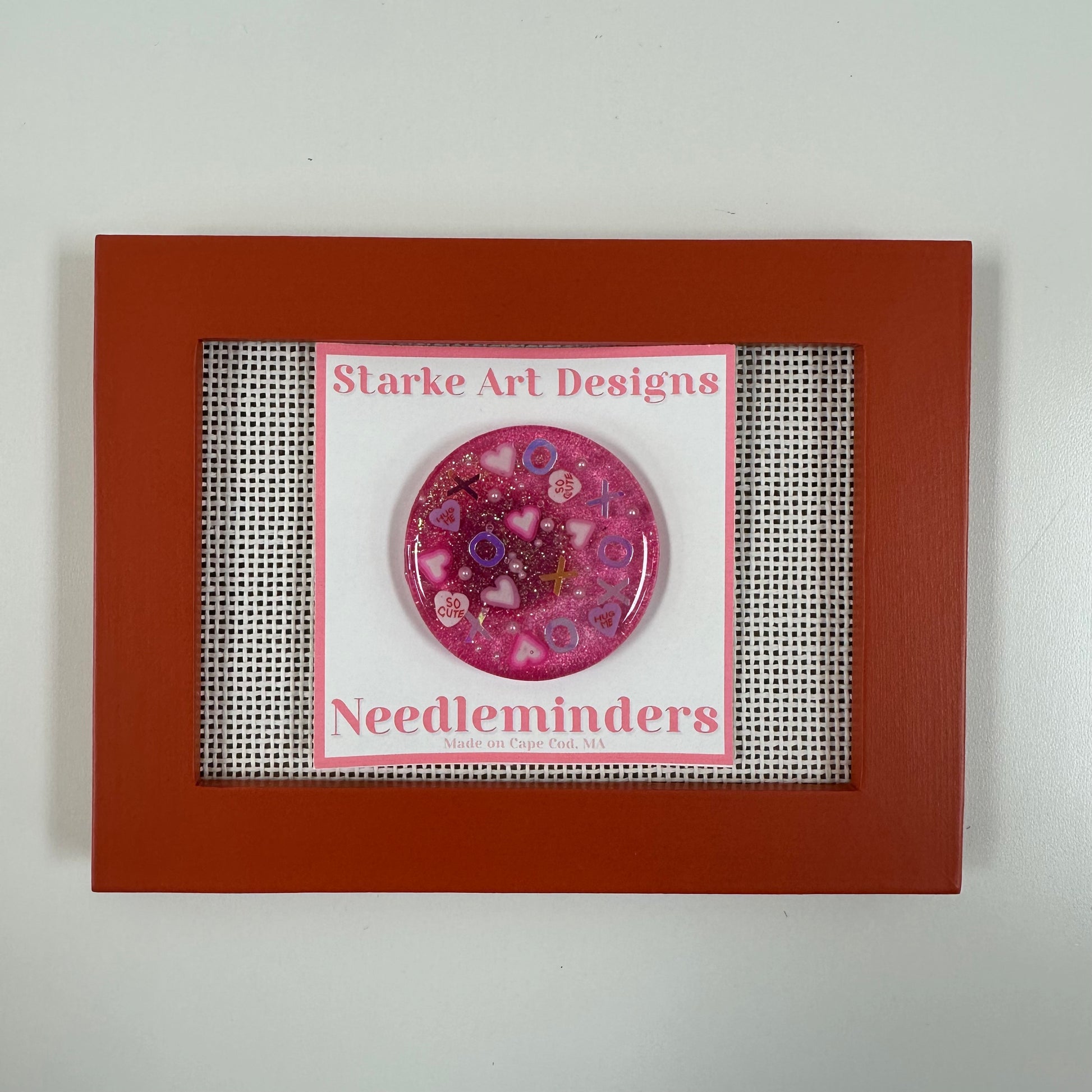 Pink needle minder with 'Starke Art Designs' branding in a red frame.
