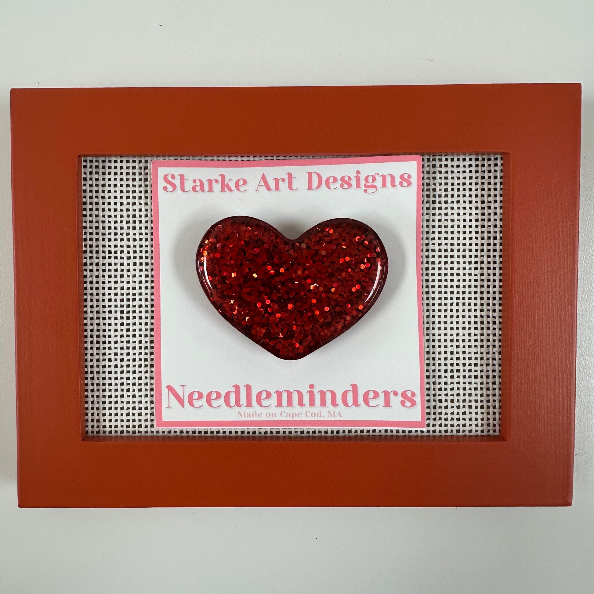 Red glittery heart needle minder on a Starke Art Designs card in a red frame.