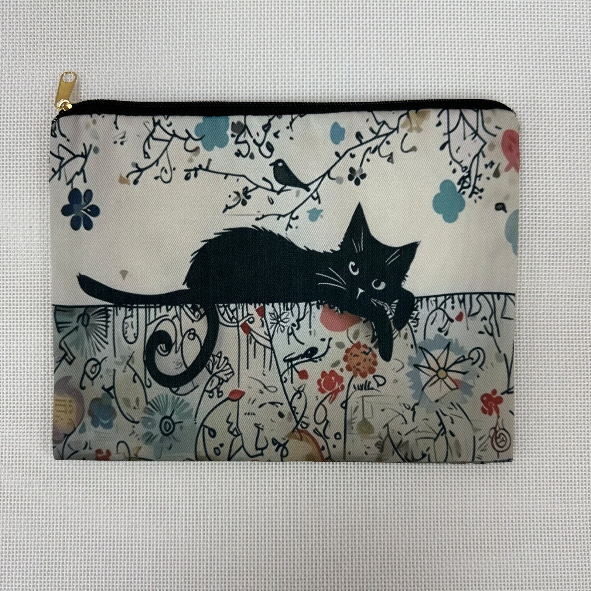 Pouch with a black cat design on a floral and branch patterned background