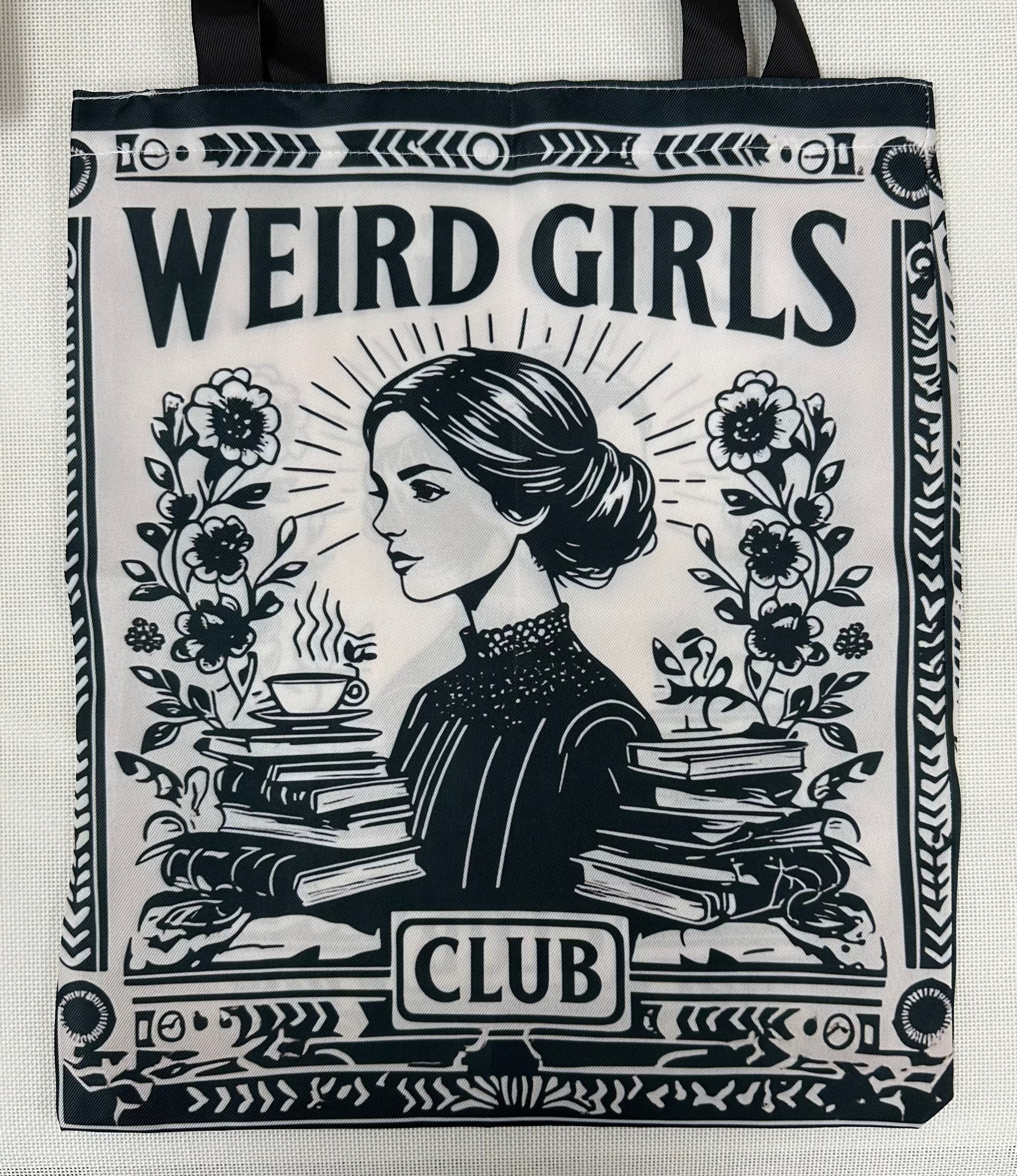 Tote bag with 'Weird Girls Club' design featuring a woman, books, and flowers.