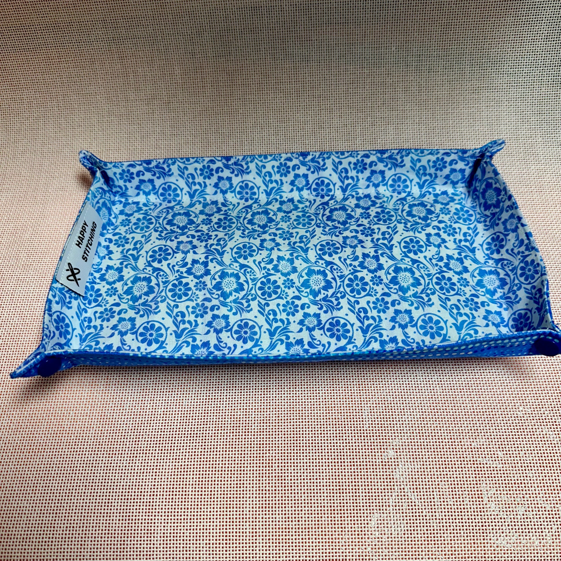 Blue patterned fabric tray on a beige surface