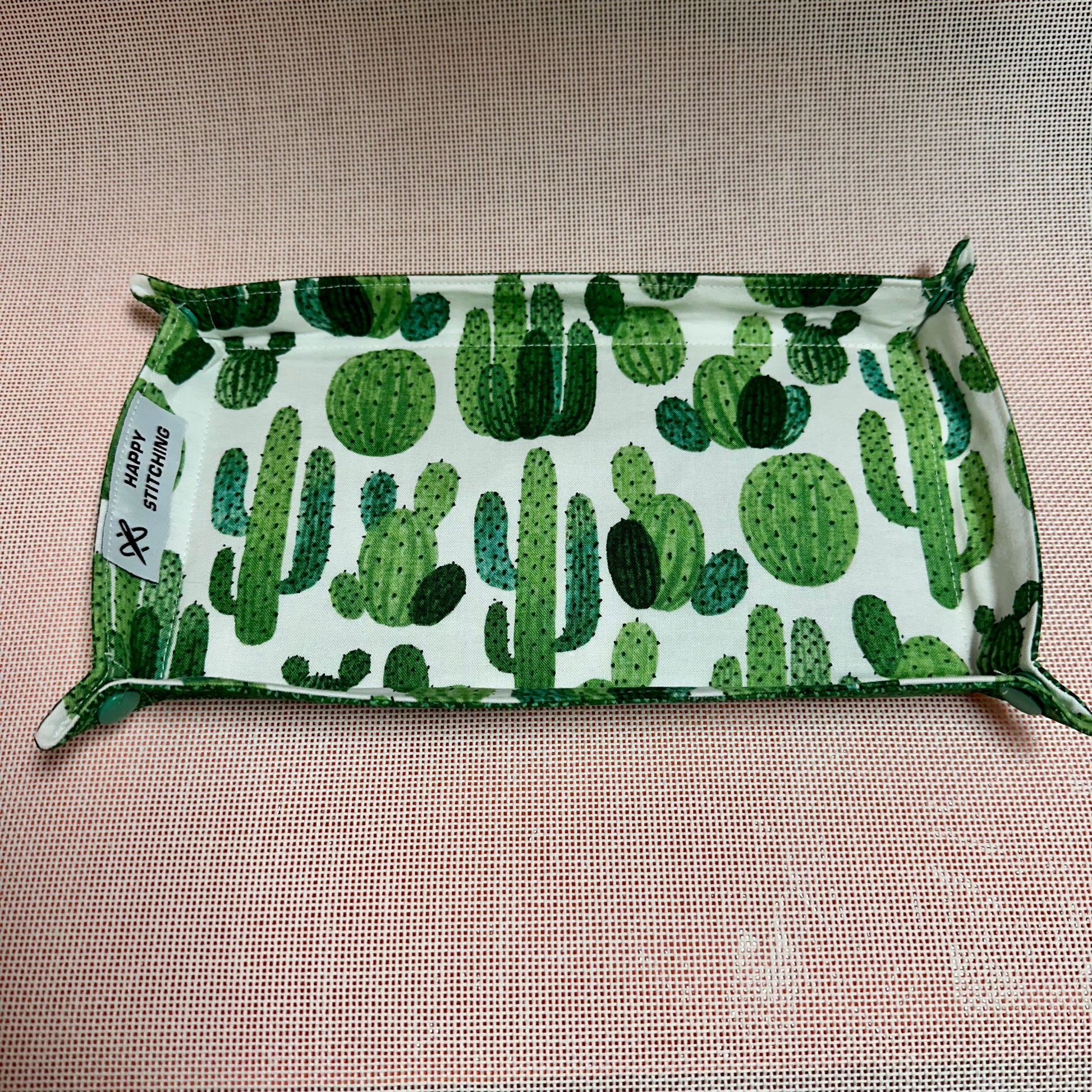 Fabric with green cactus pattern on a beige background