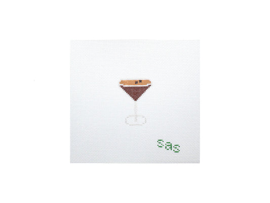 Cross-stitched design of a martini glass with olive on a white background