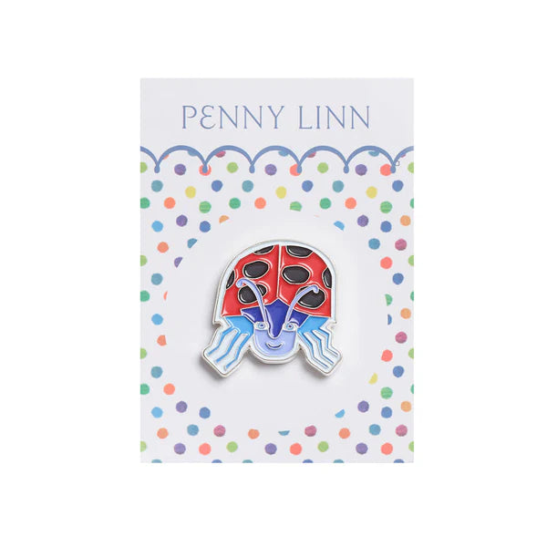 Colorful ladybug-shaped pin on a card with 'Penny Linn' branding