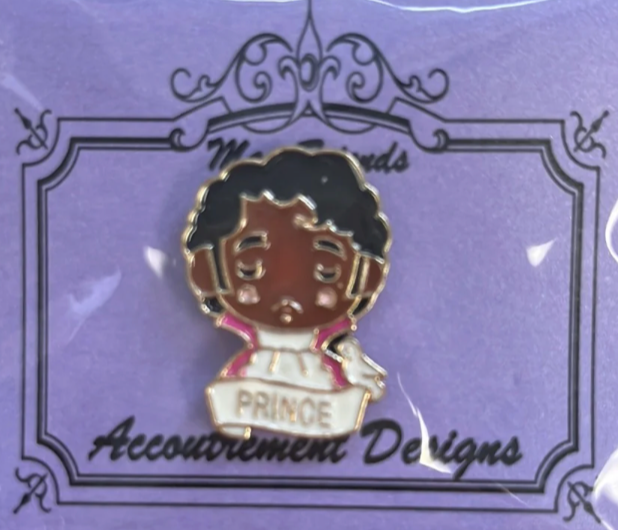 Pin with 'PRINCE' on a purple background with decorative border