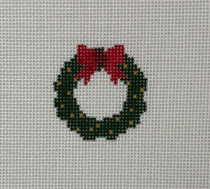 Christmas wreath with a red bow on a cross-stitched pattern