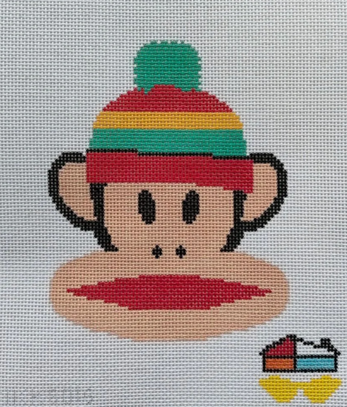 Cross-stitched design of a monkey with a colorful hat on a gray background