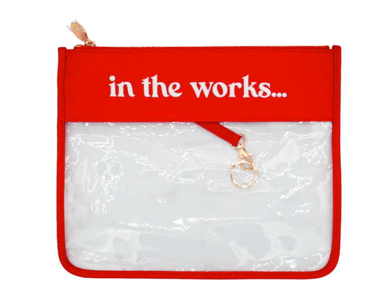 Red pouch with 'in the works...' text and clear pocket on a white background