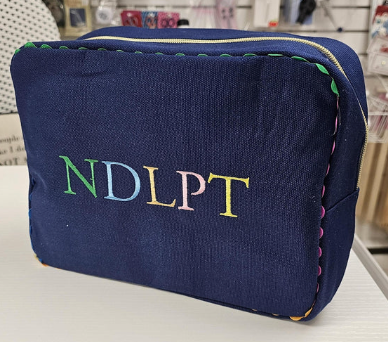 Blue pouch with colorful 'NDLPT' text on a white surface