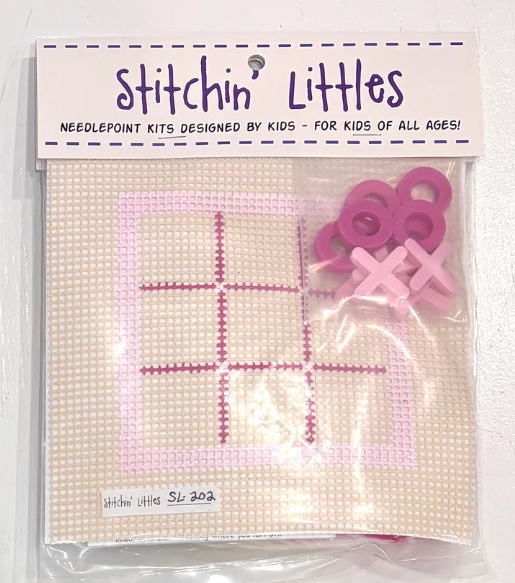 Cross-stitch kit with pink design and cross-shaped tools, branded 'Stitchin' Littles'.
