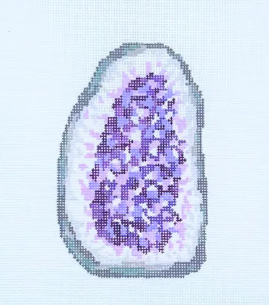 Geode with purple crystal inside on a light blue background