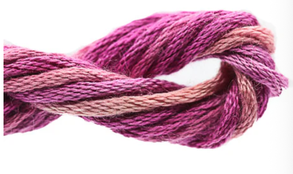 Close-up of a skein of pink and purple yarn on a white background