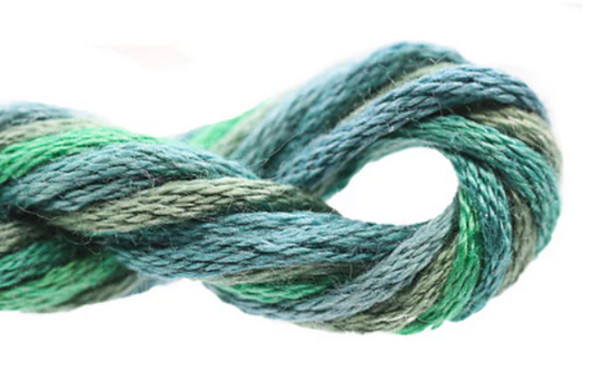 Coiled skein of green and blue yarn on a white background