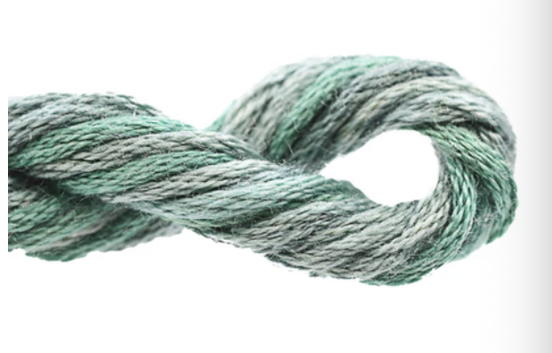 Coiled skein of green yarn on a white background