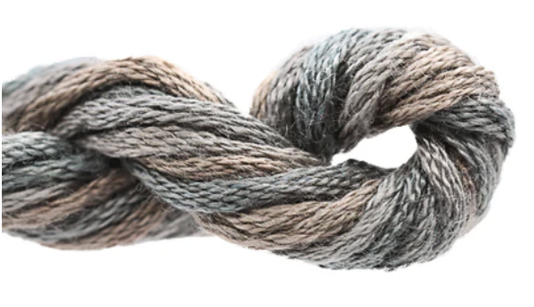 Coiled skein of gray and brown yarn on a white background