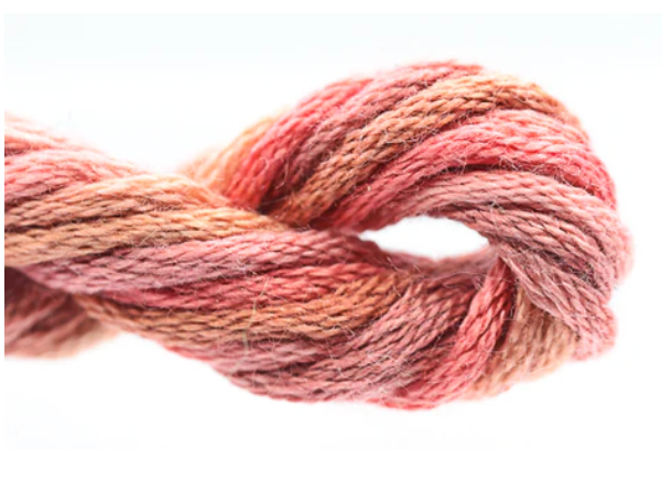 Close-up of pink and brown yarn on a white background