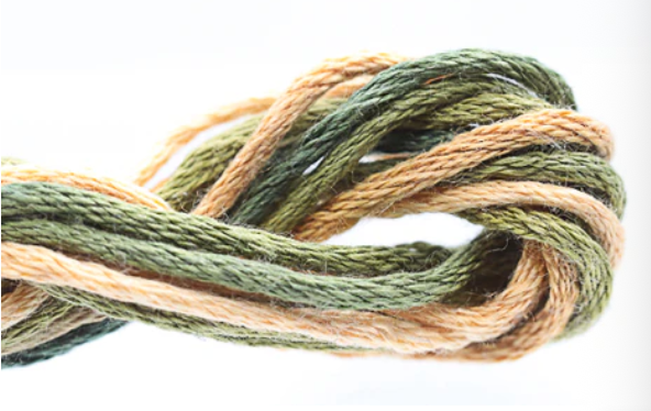 Coiled skein of green and beige yarn on a white background