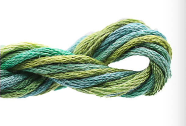 Coiled skein of green and blue yarn on a white background