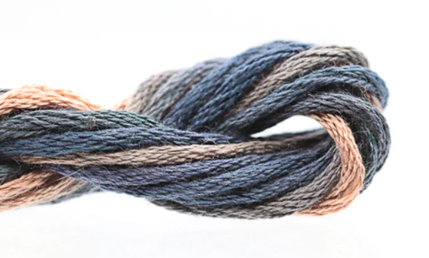 Close-up of skein of yarn with blue, brown, and beige colors on a white background