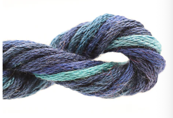 Close-up of a skein of blue and green yarn on a white background