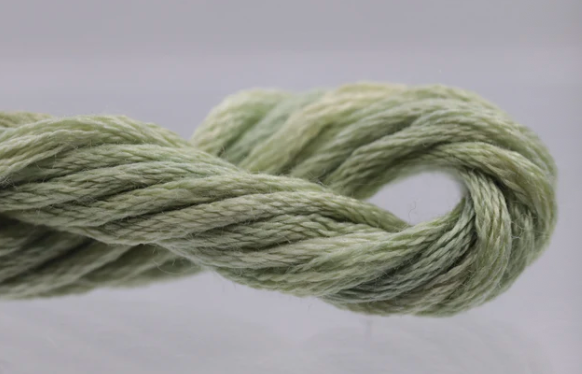 Ball of green yarn on a light gray background