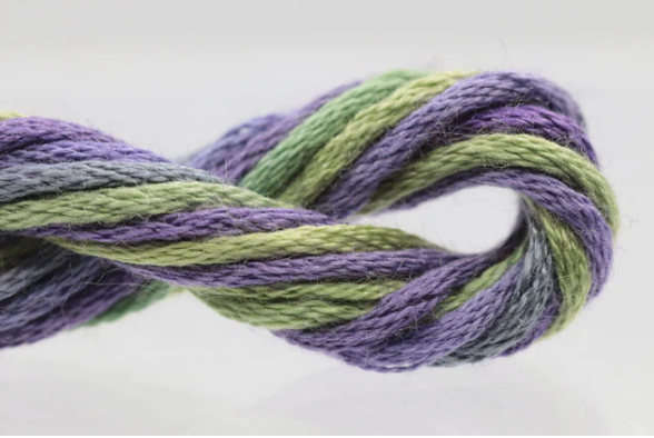 Close-up of green and purple yarn on a white background
