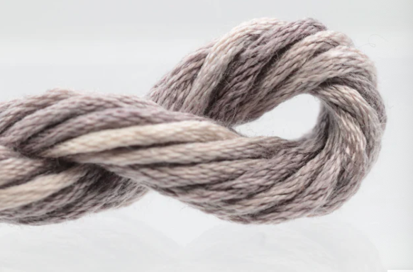Coiled gray and beige yarn on a white background