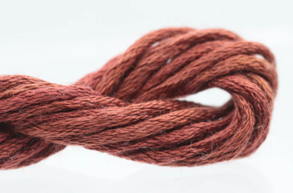 Close-up of a ball of brown yarn on a white background