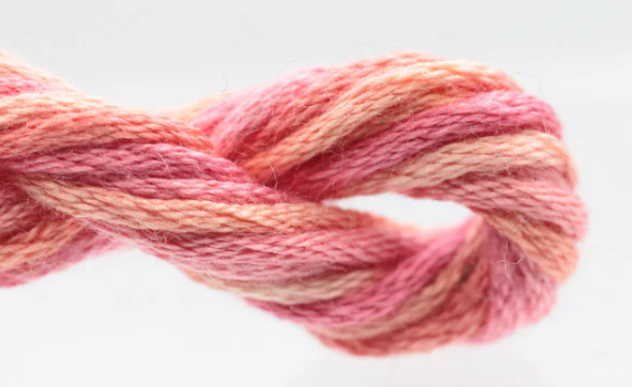 Close-up of a skein of pink and orange yarn on a white background