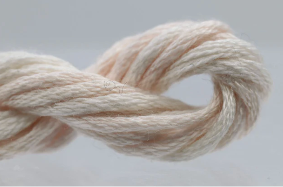 Coiled beige yarn on a light gray background